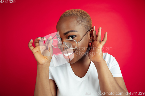 Image of African-american young woman\'s portrait on red background