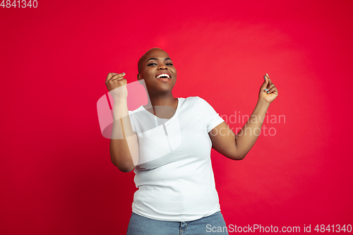 Image of African-american young woman\'s portrait on red background