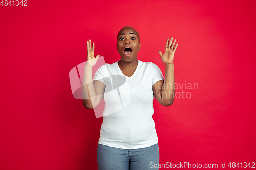 Image of African-american young woman\'s portrait on red background