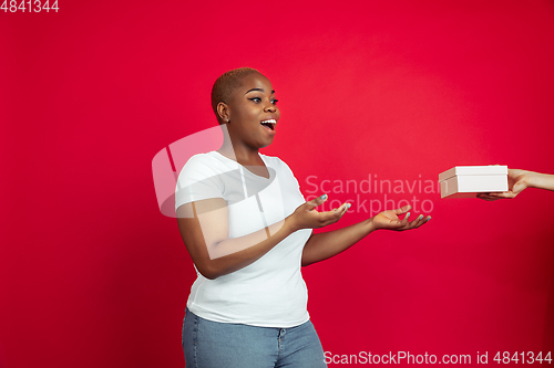 Image of African-american young woman\'s portrait on red background