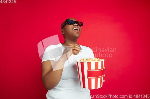 Image of African-american young woman\'s portrait on red background