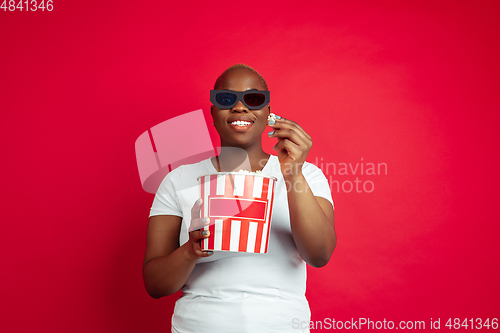 Image of African-american young woman\'s portrait on red background