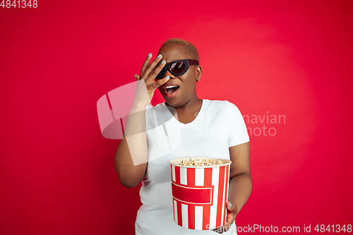 Image of African-american young woman\'s portrait on red background