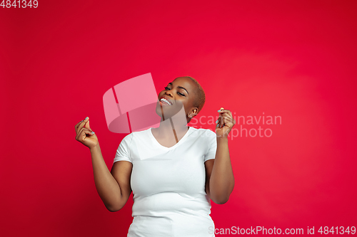 Image of African-american young woman\'s portrait on red background