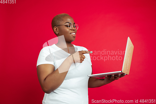 Image of African-american young woman\'s portrait on red background