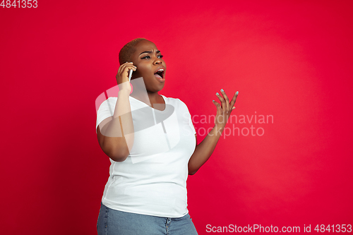 Image of African-american young woman\'s portrait on red background