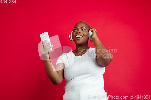 Image of African-american young woman\'s portrait on red background