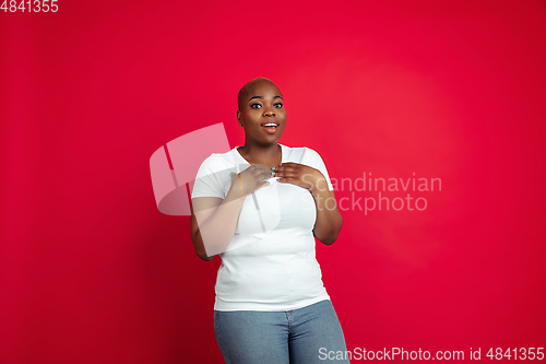 Image of African-american young woman\'s portrait on red background