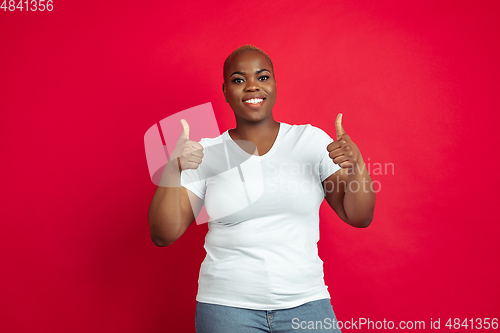 Image of African-american young woman\'s portrait on red background