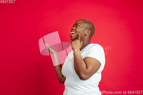 Image of African-american young woman\'s portrait on red background