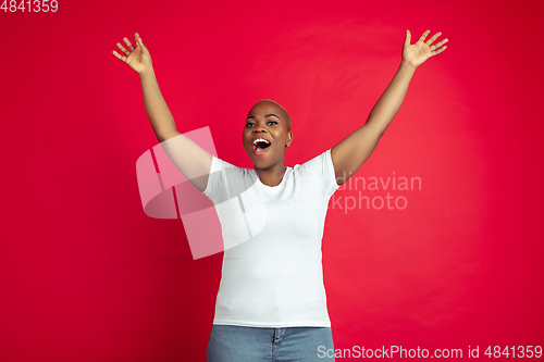 Image of African-american young woman\'s portrait on red background