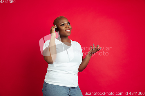 Image of African-american young woman\'s portrait on red background