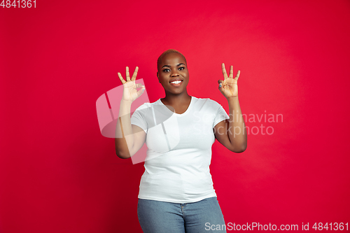 Image of African-american young woman\'s portrait on red background