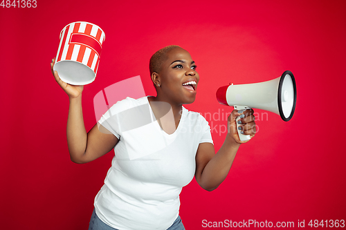 Image of African-american young woman\'s portrait on red background