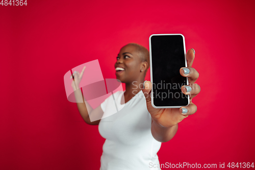 Image of African-american young woman\'s portrait on red background