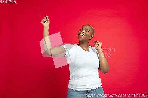 Image of African-american young woman\'s portrait on red background