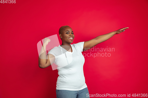 Image of African-american young woman\'s portrait on red background
