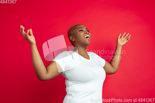 Image of African-american young woman\'s portrait on red background