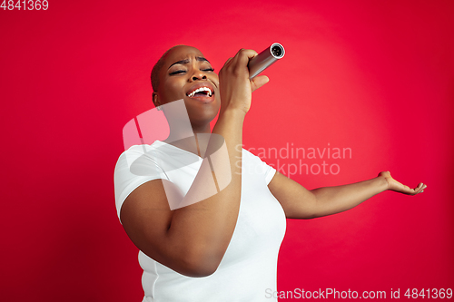 Image of African-american young woman\'s portrait on red background