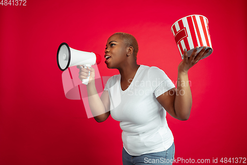 Image of African-american young woman\'s portrait on red background