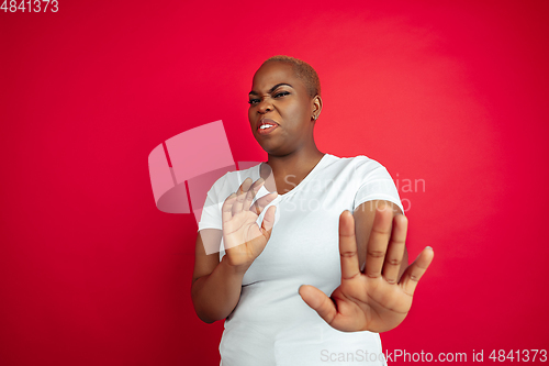 Image of African-american young woman\'s portrait on red background