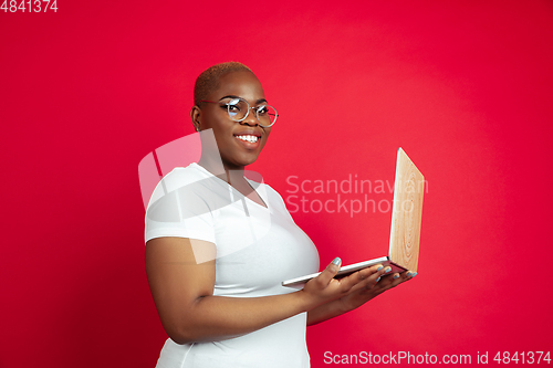 Image of African-american young woman\'s portrait on red background