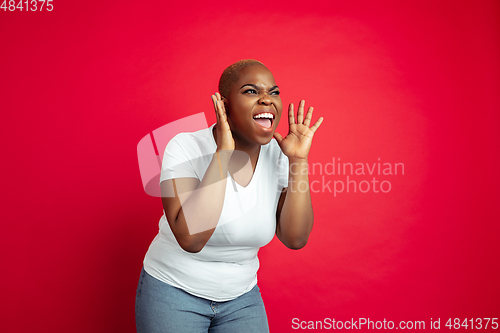 Image of African-american young woman\'s portrait on red background
