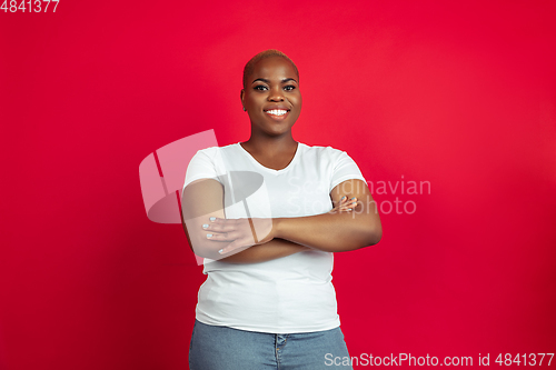 Image of African-american young woman\'s portrait on red background