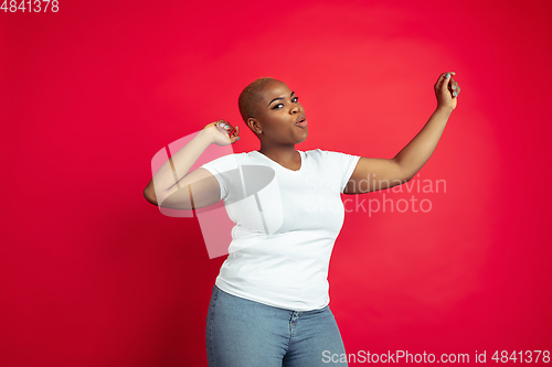 Image of African-american young woman\'s portrait on red background