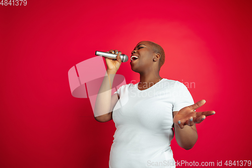 Image of African-american young woman\'s portrait on red background