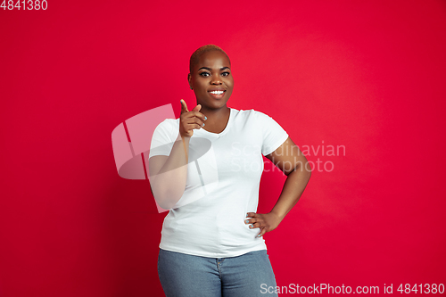 Image of African-american young woman\'s portrait on red background