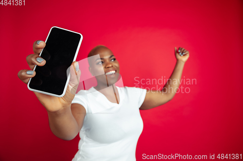 Image of African-american young woman\'s portrait on red background