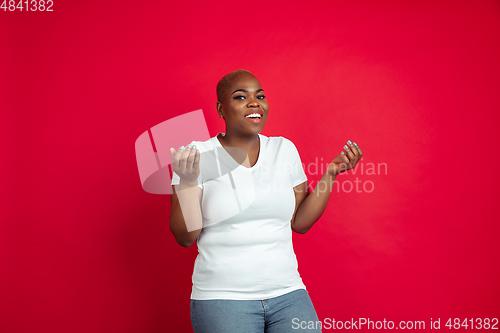 Image of African-american young woman\'s portrait on red background