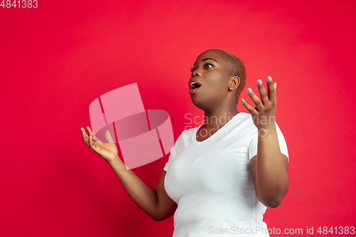 Image of African-american young woman\'s portrait on red background