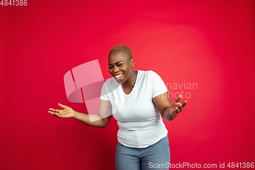 Image of African-american young woman\'s portrait on red background