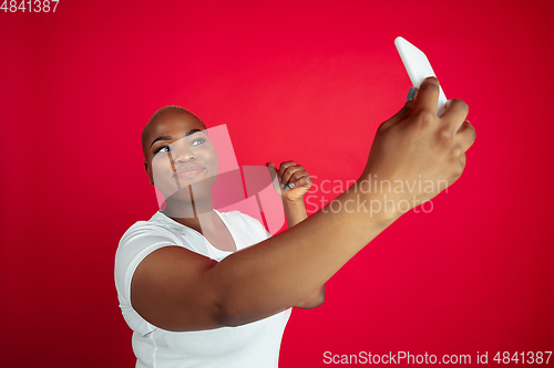 Image of African-american young woman\'s portrait on red background