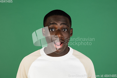 Image of African man\'s portrait isolated on green studio background with copyspace