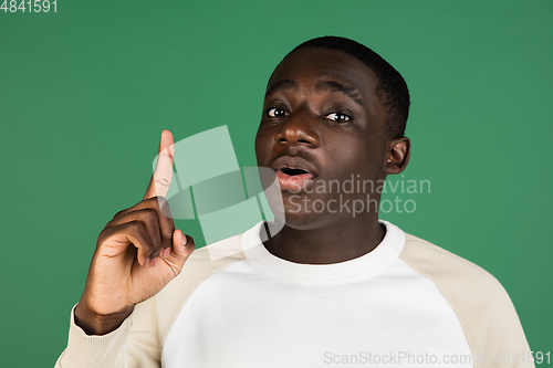 Image of African man\'s portrait isolated on green studio background with copyspace