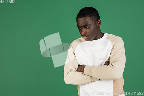 Image of African man\'s portrait isolated on green studio background with copyspace