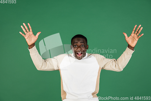 Image of African man\'s portrait isolated on green studio background with copyspace
