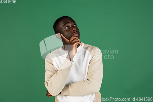 Image of African man\'s portrait isolated on green studio background with copyspace