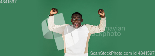 Image of African man\'s portrait isolated on green studio background with copyspace