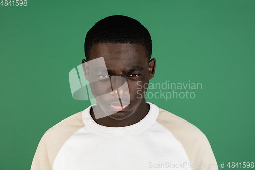 Image of African man\'s portrait isolated on green studio background with copyspace