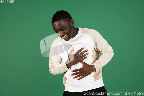 Image of African man\'s portrait isolated on green studio background with copyspace