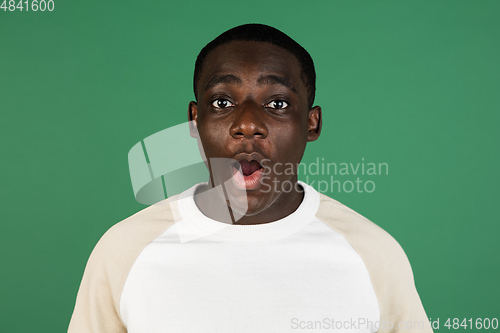 Image of African man\'s portrait isolated on green studio background with copyspace