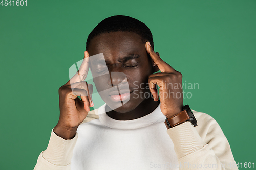 Image of African man\'s portrait isolated on green studio background with copyspace