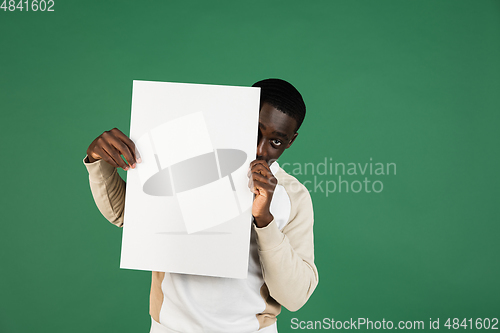 Image of African man\'s portrait isolated on green studio background with copyspace