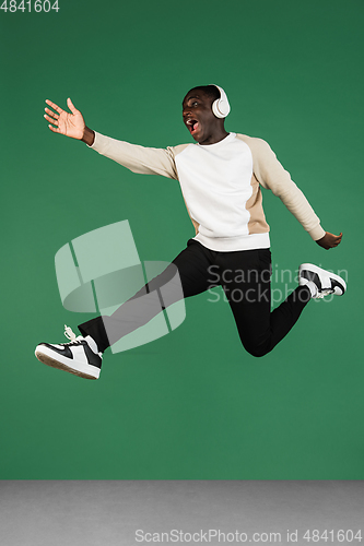 Image of African man\'s portrait isolated on green studio background with copyspace