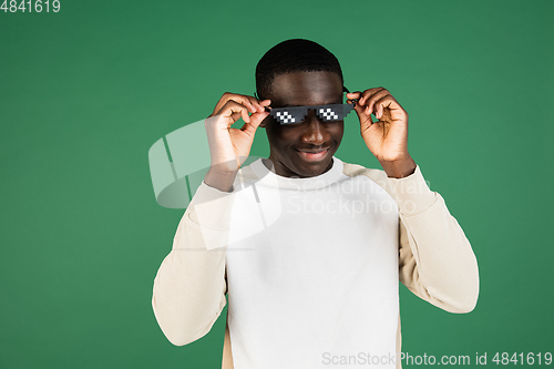 Image of African man\'s portrait isolated on green studio background with copyspace