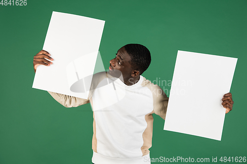 Image of African man\'s portrait isolated on green studio background with copyspace